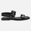 Sandalias planas de piel negra con hebilla y tachas plateadas