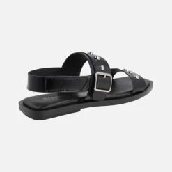 Sandalias planas de piel negra con hebilla y tachas plateadas